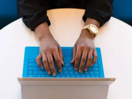 User typing on keyboard and laptop